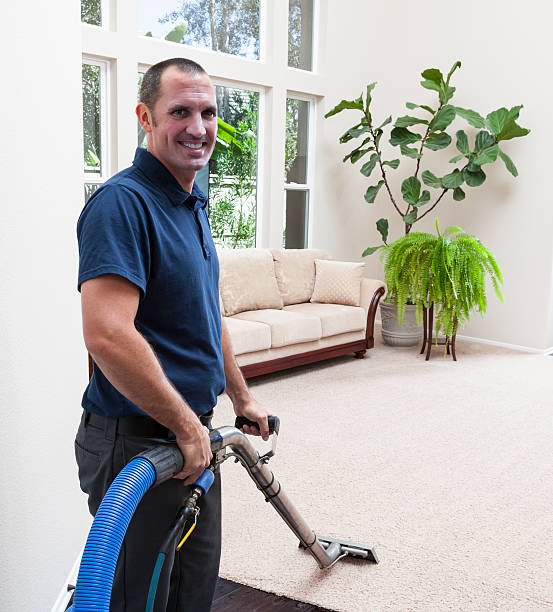 Man smiling cleaning carpets in home